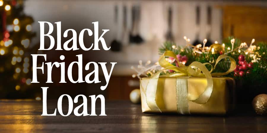 An up close image of a beautifully wrapped gold present with Christmas decor in the background. At the left, the words: Black Friday Loan.