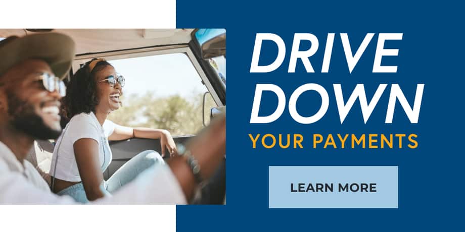 Two people happily sitting in the front seats of a moving car. The words at the right: drive down your payments.