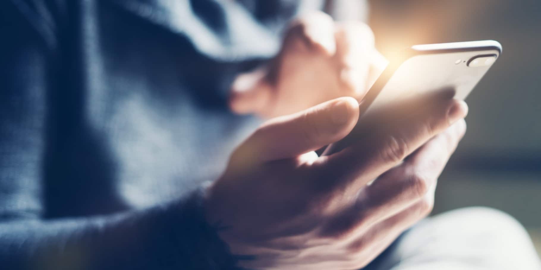 A male hand holding a mobile phone.