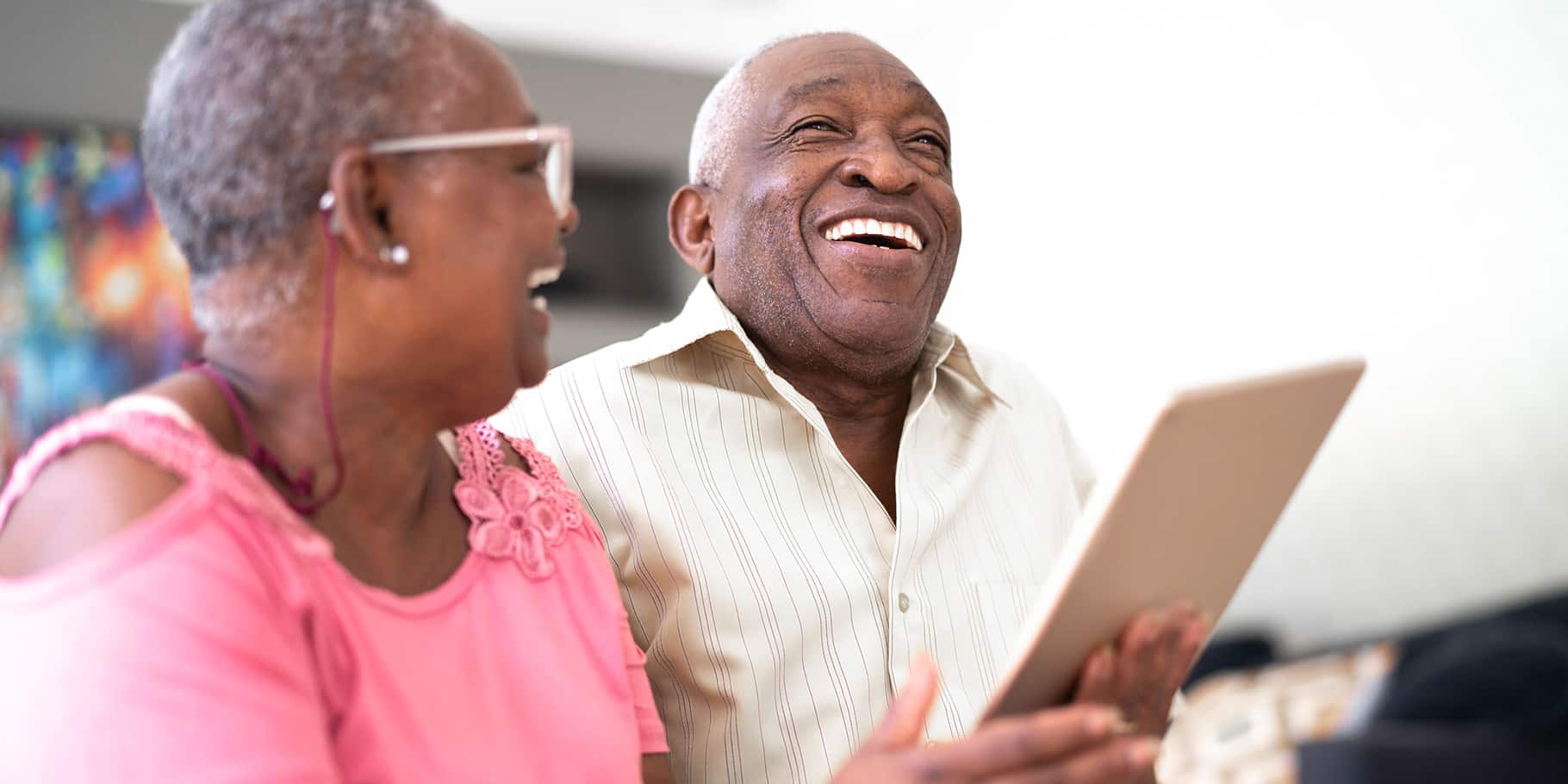 An elderly couple sitting together smiling.